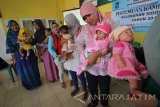 Seorang aktivis memperagakan cara menyusui saat kegiatan SosialisASI di Surabaya, Jawa Timur, Jumat (5/8). Kegiatan yang diselenggarakan oleh Asosiasi Ibu Menyusui Indonesia (AIMI) cabang Jawa Timur tersebut bertujuan untuk mensosialisasikan pentingnya menyusui di kalangan ibu-ibu sekaligus sebagai peringatan Pekan ASI Sedunia (PAS) yang dirayakan setiap 1-7 Agustus. Antara Jatim/Moch Asim/zk/16