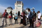 Sejumlah siswa berbincang dengan wisatawan saat mengunjungi Masjid Raya Al Mashun Medan, Sumatera Utara, Sabtu (6/8). Para pelajar SLTA dan SMK berprestasi dari Mamuju Provinsi Sulawesi Barat yang tergabung dalam "Siswa Mengenal Nusantara" kerjasama BUMN dalam rangkaian HUT RI Ke-71 tersebut melakukan perjalanan ke Sumut yang bertujuan agar seluruh siswa dapat mengenal budaya, adat istiadat dan memberikan wawasan yang lebih luas dalam mengenal nusantara. ANTARA SUMUT/Septianda Perdana/16