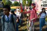 Siswa memasuki gerbang sekolah yang dibuat diorama perjuangan di SMKN 3 Jember, Jawa Timur, Senin (8/8). Diorama itu menggambarkan perjuangan para pejuang yang telah merebut kemerdekaan dari tangan penjajah dan menyambut HUT ke-71 Kemerdekaan Republik Indonesia. Antara Jatim/Seno/zk/16.