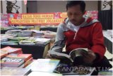 Seorang pengunjung bazar buku murah, Tono membaca buku di Gedung Nasional Indonesia (GNI) Kediri, (7/8). sekitar 50 anggota Konsorsium Penerbit Jogjakarta (KPJ) menghadirkan bazar buku murah dalam rangka aksi sejuta buku untuk Indonesia di Kediri 28 Juli -7 Agustus 2016. (Antara Jatim Foto/ Rinta/18)


