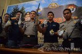 Anggota Polres Jombang menunjukan barang bukti senjata api (senpi) rakitan dan ratusan peluru tajam saat rilis di Mapolres Jombang, Jawa Timur, Selasa (9/8). Sebanyak 4 senjata api laras panjang rakitan, 4 senjata api laras pendek rakitan, ratusan butir peluru tajam berbagai kaliber dan alat pembuat senpi diamankan dari tangan BF (49) saat pengerebekan di rumahnya Desa Mancilan, Mojoagung. Tersangka dikenakan Pasal 1 Ayat 1 Undang-undang Darurat ancaman hukuman maksimal 20 tahun penjara. Antara Jatim/Syaiful Arif/zk/16