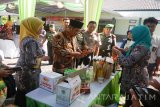 Bupati Sidoarjo Saiful Ilah (dua kiri) melihat hasil produksi pertanian dalam kegiatan temu wicara dan juga penyerahan mesin pertanian di halaman Kodim 0816 Kabupaten Sidoarjo, Selasa (9/8). Dalam kesempatan tersebut dirinya meminta kepada petani untuk mengoptimalkan penggunaan mesin pertanian demi swasembada pangan. Antarajatim/Indra Setiawan/zk/16