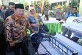 Bupati Sidoarjo Saiful Ilah (kiri) melihat salah satu mesin pertanian pada  kegiatan temu wicara dan juga penyerahan mesin pertanian di halaman Kodim 0816 Kabupaten Sidoarjo, Selasa (9/8). Dalam kesempatan tersebut dirinya meminta kepada petani untuk mengoptimalkan penggunaan mesin pertanian demi swasembada pangan. Antarajatim/Indra Setiawan/zk/16