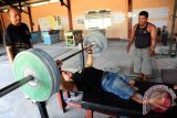 Seorang atlet angkat berat National Paralympic Committe (NPC) Kalbar didampingi pelatih dan rekannya saat menjalani latihan di kawasan GOR Pontianak, Jumat (12/8). Sebanyak 11 atlet angkat berat NPC Kalbar menjalani latihan persiapan untuk bertanding dalam Pekan Paralimpik Nasional (Peparnas) 2016 atau pekan olahraga nasional bagi atlit difabel pada Oktober mendatang. ANTARA FOTO/Jessica Helena Wuysang/16