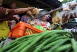 Seorang jamaah calon haji Supiyati (Kanan) melayani sejumlah konsumennya di Desa Sumber Sanan Kulon, Blitar, Jawa Timur, Jumat (12/8). Supiyati (70) yang kesehariannya berdagang sayur keliling tersebut akhirnya dapat menunaikan ibadah haji tahun 2016, dimana biayanya berasal dari keuntungan beragang yang ditabung selama kurang lebih 30 tahun. Antara Jatim/Irfan Anshori/zk/16