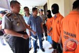 Kapolresta Medan Kombes Pol Mardiaz Kusin Dwihananto (kiri) bersama jajarannya berbincang dengan kedua pelaku penghasut dan penggeroyokan berinisial MK dan IM yang diamankan di Mapolresta Medan, Sumatera Utara, Kamis (11/8). Polresta Medan menangkap dua orang pelaku penghasut dan penggeroyokan terhadap empat anggota Polisi saat sedang melakukan penggerebekan narkoba di kawasan Kampung Aur Medan. ANTARA SUMUT/Septianda Perdana/16