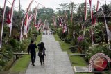 Wisatawan mengunjungi Desa Tradisional Penglipuran di Bangli, Bali, Jumat (12/8). Desa yang terkenal akan kerukunan dan kebersamaan berlandaskan adat istiadat setempat serta memiliki pola permukiman yang tertata apik ini meriah dihiasi bendera dan umbul-umbul merah putih dalam rangka menyambut HUT RI. ANTARA FOTO/Ismar Patrizki/wdy/16.