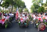 Sejumlah delegasi dari Surabaya Lintas Budaya Internasional 'Surabaya Cross Culture Festival International' 2016 naik becak ketika parade melintasi car free day di Raya Darmo, Surabaya, Jawa Timur, Minggu (14/8). Perhelatan seni yang digelar tiap tahun dengan menampilkan kesenian dari beberapa provinsi di Indonesia dan enam negara luar negeri tersebut, bertujuan untuk menjalin persahabatan dan kerjasama dengan bidang seni. ANTARA FOTO/M Risyal Hidayat/wdy/16