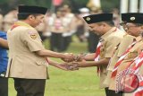 Presiden RI Joko Widodo (kiri) saat menyerahkan penghargaan kepada Gubernur Lampung M.Ridho Ficardo (kanan) pada puncak Peringatan Hari Pramuka ke-55 dan Pembukaan Jambore Nasional Ke-X 2016, di Bumi Perkemahan Cibubur, Jakarta. (ANTARA FOTO/Humas Pemprov Lampung/Dok).