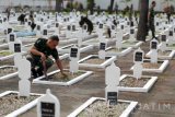 Sejumlah prajurit TNI AD dari Kodim 0808/Blitar membersihkan dan memasang lilin pada tiap pusara makam di Taman Makam Pahlawan (TMP) Raden Wijaya, Blitar, Jawa Timur, Selasa (16/8). Pembersihan dan pemasangan lilin tersebut dalam rangka mempersiapkan upacara malam renungan suci yang biasanya dilaksanakan pada malam jelang pergantian hari peringatan kemerdekaan RI. Antara Jatim/Irfan Anshori/zk/16