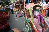 Pasangan suami istri menaiki becak guna diarak berkeliling kota usai mengikuti nikah massal di Balai Kota Kediri, Jawa Timur, Rabu (17/8). Nikah massal yang diikuti 17 pasangan dari keluarga kurang mampu tersebut dalam rangka peringatan hari jadi ke-1137 Kota Kediri sekaligus memeriahkan hari kemerdekaan ke-71 RI. Antara Jatim/Prasetia Fauzani/zk/16