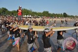 Sejumlah pemuda menggotong papan selancar berukuran raksasa saat memperingati HUT ke-71 Proklamasi Kemerdekaan RI di Pantai Kuta, Bali, Rabu (17/8). Selancar berukuran 6 x 1,2 meter tersebut diuji coba bersama sekitar 300 peselancar sehingga dapat tercatat dalam Museum Rekor Indonesia (MURI) sebagai papan selancar terbesar di Asia. ANTARA FOTO/Nyoman Budhiana/i018/2016.