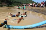 Tiga peselancar yang menjadi petugas pengibar bendera merah putih bergerak ke tepi muara Pantai Pancer Door, Pacitan, Jawa Timur, Rabu (17/8). Sebanyak 200-an nelayan, peselancar dan komunitas pecinta lingkungan menggelar upacara bendera memperingati HUT ke-71 Kemerdekaan RI. Antara jatim/Destyan Sujarwoko/zk/16