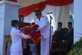 Bupati Kubu Raya Rusman Ali serahkan Bendera Merah Putih kepada Pasukan Pengibar Bendera Pusaka (Paskibraka) saat Upacara Peringatan HUT ke-71 Kemerdekaan RI di Halaman Kantor Bupati Kubu Raya Rabu (17/8). (Foto Humas Kabupaten Kubu Raya)
