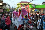 Ribuan warga melihat peserta karnaval yang melintas di Jalan Jemur Wonosari Surabaya, Minggu (21/8). Karnaval yang diikuti ribuan peserta dari warga RW-05 tersebut dalam rangka menyemarakkan peringatan HUT ke-71 kemerdekaan Republik Indonesia. Antara Jatim/Abdullah Rifai/zk/16