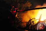 Seorang wartawan mengambil gambar api yang membakar hutan di Jalan Parit Haji Husin II, Pontianak, Kalbar, Sabtu (20/8) malam. Kebakaran lahan yang terjadi pada sore hari dan sudah berhasil dipadamkan tersebut, kembali menyala pada malam hari. Hal itu disebabkan karena masih ada bara api yang tersimpan di bawah permukaan tanah gambut. ANTARA FOTO/Jessica Helena Wuysang/16

