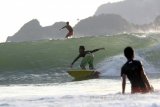 Sejumlah peselancar berlatih di Pantai Pulau Merah, Banyuwangi, Jawa Timur, Minggu (21/8). Pantai Pulau Merah tersebut, sangat cocok untuk para peselancar dari tingkat pemula hingga profesional karena tidak banyak memiliki batu karang. Antara Jatim/ Budi Candra Setya/zk/16.