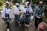 Seorang calon jamaah haji yang tergabung dalam kloter 13 asal Labuhan Batu Utara Suwito (kanan) bersama ketiga istrinya Royati (kiri), Indrawati (kedua kiri) dan Sutiani (kedua kanan), saat tiba di Embarkasi Asrama Haji Medan, Sumatera Utara, Rabu (24/8). Suwito (63) pengusaha asal Kabupaten Labuhan Batu Utara  itu berangkat haji bersama dengan tiga istrinya sekaligus atas permintaan dari istri pertama. ANTARA SUMUT/Septianda Perdana/16