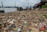 Penumpang perahu berjalan meninggalkan tepian Sungai Batanghari yang dipenuhi tumpukan sampah di Pasar Jambi, Jambi, Selasa (30/8). Penumpukan sampah yang terlihat di sejumlah titik tepian tersebut terjadi akibat kurangnya kesadaran warga dalam menjaga kebersihan sungai. ANTARA FOTO/Wahdi Septiawan/aww/16.