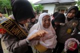 Polisi Wanita (Polwan) Polres Lhokseumawe saat menyantuni perempuan jompo Panti Asuhan Desa Punteuet, Blang Mangat, Kota Lhokseumawe, Provinsi Aceh. Penyantunan sembako bagi puluhan perempuan lansia itu sebagai ungkapan terimakasih dan kasih sayang Polwan kepada kaum perempuan (ibu) itu serangkaian kegiatan memperingati HUT Ke-68 Polwan Indonesia tahun 2016 di Aceh. (ANTARA FOTO/Rahmad/Dok).