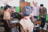 Mendikbud, Muhadjir Effendy (kanan) menanyai seorang siswa saat memantau penyaluran Kartu Indonesia Pintar (KIP) di SDN 1 Mangliawan 1, Malang, Jawa Timur, Jumat (2/9). Kemendikbud mencatat penyaluran dana Kartu Indonesia Pintar (KIP) hanya mencapai 50 persen sehingga penyalurannya akan dihentikan jika hingga akhir bulan September tetap tidak maksimal. Antara Jatim/Ari Bowo Sucipto/zk/16.