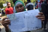 Yanti (40) menunjukan formulir pembuatan Kartu Tanda Penduduk elektronik (e-KTP), namun teraksa harus pulang karena nomor antrean habis di Dinas Kependudukan Catatan Sipil (Disdukcapil) Kabupaten Jombang, Jawa Timur, Selasa (6/9). Ratusan warga di Jombang terpaksa mengantre mulai pukul 05.00 WIB untuk mendapatkan nomor antrean pembuatan e-KTP, karena lima dari enam alat perekam rusak dan sehari dibatasi hanya 200 orang pemohon e-KTP. Antara Jatim/Syaiful Arif/zk/16