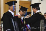Rektor Institut Teknologi Sepuluh Nopember (ITS) Surabaya Joni Hermana (kanan) mengukuhkan Kuswandi (kedua kiri) sebagai profesor jurusan Teknik Kimia saat pengukuhan Guru Besar ITS di Graha ITS Surabaya, Jawa Timur, Rabu (7/9). Dalam kesempatan tersebut ada tiga guru besar yang dikukuhkan yakni Aulia Siti Aisjah sebagai guru besar di jurusan Teknik Fisika, Kuswandi di jurusan Teknik Kimia dan Muhammad Sigit Darnawan di jurusan Diploma Teknik Sipil. Antara Jatim/M Risyal Hidayat/zk/16