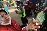 Petugas menempelkan stiker tanda uji emisi saat digelarnya operasi uji emisi kendaraan di Tulungagung, Jawa Timur, Rabu (7/9). Pemeriksaan acak pada 100 unit mobil dan angkutan umum berbahan premium maupun solar itu digelar untuk mengetahui kadar emisi gas buang kendaraan yang bisa memicu polusi udara di wilayah perkotaan Jatim. Antara Jatim/Destyan Sujarwoko/zk/16