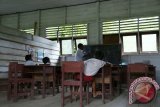 Tiga siswa didampingi gurunya belajar di ruang kelas yang sepi di Sekolah Dasar Negeri 004 Nyaribungan di Kecamatan Laham, Kabupaten Mahakam Hulu, Kalimantan Timur, Selasa (6/9). Kondisi tersebut terjadi karena sejumlah siswa meninggalkan sekolahnya untuk bekerja mencari emas di sungai bersama orangtuanya di lokasi yang berjarak 30 kilometer dari pemukiman. Hal tersebut biasanya berlangsung hingga satu bulan. ANTARA FOTO/Sugeng Hendratno/jhw/16