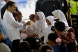 Presiden Joko Widodo (kiri) menyerahkan bantuan makanan tambahan untuk anak sekolah saat berkunjung ke Kampung Nelayan Karangantu, di Serang, Banten, Minggu (11/9). Presiden menyerahkan 1.000 paket sembako dan makanan bergizi khusus untuk ibu hamil, balita serta anak sekolah sekaligus menyerahkan bantuan seekor sapi untuk kurban untuk keluarga nelayan. ANTARA FOTO/Asep Fathulrahman/NZ/16