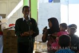 Presiden Joko Widodo (Jokowi) berdialog dengan istri nelayan di TPI Desa Landangan, Kapongan, Situbondo, Jawa Timur, Rabu (14/9). Dalam kunjungannya Presiden Jokowi membagi-bagikan biskuit kepada anak-anak, ibu hamil, dan ibu yang memiliki balita dalam Program Pemberian Makanan Tambahan (PMT).Antara Jatim/Seno/zk/16. 
