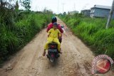 Seorang anak tanpa mengenakan pelindung kepala atau helm duduk di motor dalam posisi terbalik saat melintasi jalan di Parit Suka Maju, Pontianak Utara, Kalbar, Rabu (14/9). Tindakan tidak mematuhi peraturan lalu lintas dan mengabaikan keselamatan anak yang dibonceng tersebut, rawan mengalami kecelakaan bermotor. ANTARA FOTO/Jessica Helena Wuysang/16