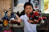 Aji Wahyu Santoso (17) menunjukkan hasil kerajinan pembuatan miniatur motor berbahan utama kertas bekas di Desa Sudimoro, Megaluh, Jombang, Jawa Timur, Sabtu (17/9). Kerajinan miniatur motor berbagai jenis yang memanfaatkan sejumlah limbah tersebut dijual Rp 15 ribu - Rp 150 ribu per biji. Antara Jatim/Syaiful Arif/zk/16