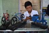 Aji Wahyu Santoso (17) menyelesaikan pembuatan miniatur motor bebahan utama kertas bekas di Desa Sudimoro, Megaluh, Jombang, Jawa Timur, Sabtu (17/9). Kerajinan miniatur motor berbagai jenis yang memanfaatkan sejumlah limbah tersebut dijual Rp 15 ribu - Rp 150 ribu per biji. Antara Jatim/Syaiful Arif/zk/16