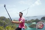 Seorang wisatawan mancanegara saat berfoto diri dengan latar belakang pemandangan di Pianemo, Raja Ampat, Papua Barat, Indonesia. Untuk menempuh menuju lokasi tersebut dari Waigeo di Waisai (Ibu Kota Kabupaten Raja Ampat) adalah dua jam perjalanan, dengan menyewa 'speed boat' seharga Rp5 juta sehari. (ANTARA FOTO/Regina Safri/Dok). 