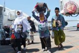 Jamaah haji yang tergabung dalam kelompok terbang (kloter) pertama tiba di Bandara Internasional Juanda Surabaya di Sidoarjo, Jawa Timur, Minggu (18/9/16). Sebanyak 445 jamaah haji haji kloter pertama asal Sumenep, Madura kembali ke tanah air setelah menunaikan ibadah haji. (ANTARA FOTO/Umarul Faruq/Dok).