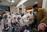 Gubernur Sumut Tengku Erry Nuradi menyalami para jamaah haji asal Kabupaten Labuhan Batu yang telah tiba di tanah air saat disambut di Asrama Haji Embarkasi Medan, Sumatera Utara, Senin (19/9). Sebanyak 391 haji asal Kabupaten Labuhan Batu yang tergabung pada kloter kedua tiba di tanah air setelah menunaikan ibadah haji di Mekkah. ANTARA SUMUT/Septianda Perdana/16