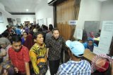 Pimpinan Ombudsman Republik Indonesia (ORI) Ahmad Alamsyah Saragih (tengah) didampingi Kepala Perwakilan Ombudsman Sumut Abyadi Siregar (kiri) berbincang dengan warga saat mengurus perekaman data E-KTP di kantor Dinas Kependudukan dan Pencatatan Sipil Kota Medan, Sumatera Utara, Kamis (15/9). Ombudsman RI akan mengawal proses pelayanan perekaman kartu tanda penduduk elektronik (E-KTP) terkait kebijakan tenggat waktu perekaman data E-KTP oleh Kemendagri di seluruh Indonesia untuk mengetahui efektivitas penyediaan pelayanan yang diberikan pemerintah terhadap masyarakat. ANTARA SUMUT/Septianda Perdana/16
