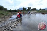 Sejumlah pengendara motor melintasi jembatan di atas Taman Nasional Danau Sentarum (TNDS) yang sedang mengalami musim kering di Kabupaten Kapuas Hulu, Kalbar, Minggu (18/9). Kawasan TNDS seluas 132 ribu hektar yang merupakan salah satu objek wisata unggulan Kabupaten Kapuas Hulu tersebut, mengalami dua musim yaitu musim kering dan musim pasang. ANTARA FOTO/Victor Fidelis Sentosa/jhw/16