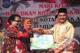 Menteri PPPA Yohana Yambise memberikan penghargaan untuk Wali Kota Pangkalpinang M Irwansyah yang diwakili oleh Wakil Wali Kota Pangkalpinang M Sopian sebagai inisiator Kota Pangkalpinang menuju kota layak anak, Sabtu (17/9/2016). (Foto Antara/Mahendra).