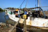 Buruh menurunkan pasir dari atas perahu di Desa Pademawu Timur,  Pamekasan, Jatim, Selasa (20/9). Mereka mendapat upah Rp15.000  untuk setiap mengangkut sebanyak 2.8 meter kubik pasir. Antara Jatim/Saiful Bahri/zk/16