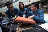 Mahasiswa jurusan teknik manufaktur Universitas Surabaya (Ubaya) Christian Darwinto Ekoputro (kiri), Valencia Lilian Utomo (tengah) serta Indra Kusuma Wardana (kanan) memperlihatkan kinerja prototype EZ2Stand (alat bantu berdiri bagi lansia) saat mengikuti kompetisi desain dan produk di Surabaya, Kamis (22/9). Kompetisi desain dan produk dengan tema 'Alat Bantu Disabilitas, Lansia dan Terapi'tersebut merupakan kompetisi yang diadakan dua tahun sekali oleh Jurusan Teknik Manufaktur Ubaya sebagai bentuk kepedulian terhadap hak bagi para penyandang disabilitas dan para lansia dalam beraktifitas. Antara Jatim/Moch Asim/zk/16