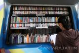 Warga memanfaatkan mobil perpustakaan keliling guna membaca buku di area wisata monumen Simpang Lima Gumul, Kediri, Jawa Timur, Minggu (25/9). Mobil perpustakaan dengan koleksi ribuan judul buku tersebut bertujuan meningkatkan minat baca warga yang menurut data dari The Organisation For Econimic Co-operation and Development (OECD) budaya membaca masyarakat Indonesia berada di peringkat rendah se Asia. Antara Jatim/Prasetia Fauzani/zk/16