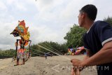 Peserta menarik layang-layang berukuran besar saat berlangsungnya Serang Beach Kite Festival 2016 di Pantai Serang, Kecamatan Panggungrejo, Blitar, Jawa Timur, Minggu (25/9). Festival layang-layang yang diikuti sekitar 115 peserta dari berbagai klub layang-layang se indonesia tersebut digelar dengan tujuan untuk mendongkrak angka kunjungan wisata di kawasan pantai selatan pulau jawa, terutama obyek wisata Pantai Serang. Antara Jatim/Irfan Anshori/zk/16