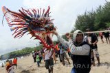 Peserta menarik layang-layang berukuran besar saat berlangsungnya Serang Beach Kite Festival 2016 di Pantai Serang, Kecamatan Panggungrejo, Blitar, Jawa Timur, Minggu (25/9). Festival layang-layang yang diikuti sekitar 115 peserta dari berbagai klub layang-layang se indonesia tersebut digelar dengan tujuan untuk mendongkrak angka kunjungan wisata di kawasan pantai selatan pulau jawa, terutama obyek wisata Pantai Serang. Antara Jatim/Irfan Anshori/zk/16