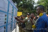 Menteri Desa, Pembangunan Daerah Tertinggal (PDT) dan Transmigrasi, Eko Putro Sandjojo (kanan) mendengarkan paparan Kepala Desa Metesih, Paidjo (kiri) tentang pelaksanaan proyek yang menggunakan dana Bantuan Keuangan Desa 2015 saat melakukan kunjungan kerja di Desa Metesih, Jiwan, Kabupaten Madiun, Jawa Timur, Senin (26/9). Kegiatan tersebut merupakan bagian dari rangkaian kegiatan kunjungan kerja Menteri Eko Putro Sandjojo di Kabupaten Madiun, selain memberikan pengarahan dan Kepala Desa se-Kabupaten Madiun. Antara Jatim/Foto/Siswowidodo/zk/16