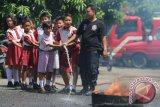 Sejumlah siswa SD dibantu petugas pemadam kebakaran menyemprotkan air pada simulasi pemadam kebakaran, di Medan, Sumatra Utara, Senin (26/8). Simulasi tersebut untuk mengenalkan kepada para siswa tentang tugas dan fungsi pemadam kebakaran dan upaya awal ketika terjadi kebakaran. ANTARA SUMUT/Irsan Mulyadi/16