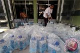 Petugas haji menyediakan air zam-zam bagi jamaah haji  di Asrama Haji Embarkasi Medan, Sumatera Utara, Kamis (22/9). Panitia Penyelenggara Ibadah Haji (PPIH) Embarkasi Medan menyediakan 15.000 liter air zam-zam dan membagikan secara cuma-cuma lima liter air zam-zam gratis kepada setiap jamaah yang tiba di Tanah Air. ANTARA SUMUT/Septianda Perdana/16  