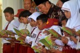 Bupati Sidoarjo Saiful Ilah (tengah) menyimak sejumlah pelajar membaca buku saat acara Gelar Baca Anak di Pendopo Sidoarjo, Jawa Timur, Selasa (27/9). Mobil perpustakaan keliling dengan koleksi ribuan judul buku tersebut bertujuan meningkatkan minat baca warga yang menurut data UNESCO, minat membaca masyarakat Indonesia tergolong sangat rendah, hanya sekitar 0,01 persen atau setiap 1.000 orang membaca satu buku. Antara Jatim/Umarul Faruq/zk/16