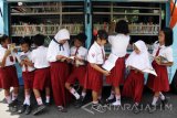 Sejumlah membaca buku di mobil perpustakaan keliling saat acara Gelar Baca Anak di Pendopo Sidoarjo, Jawa Timur, Selasa (27/9). Mobil perpustakaan keliling dengan koleksi ribuan judul buku tersebut bertujuan meningkatkan minat baca warga yang menurut data UNESCO, minat membaca masyarakat Indonesia tergolong sangat rendah, hanya sekitar 0,01 persen atau setiap 1.000 orang membaca satu buku. Antara Jatim/Umarul Faruq/zk/16